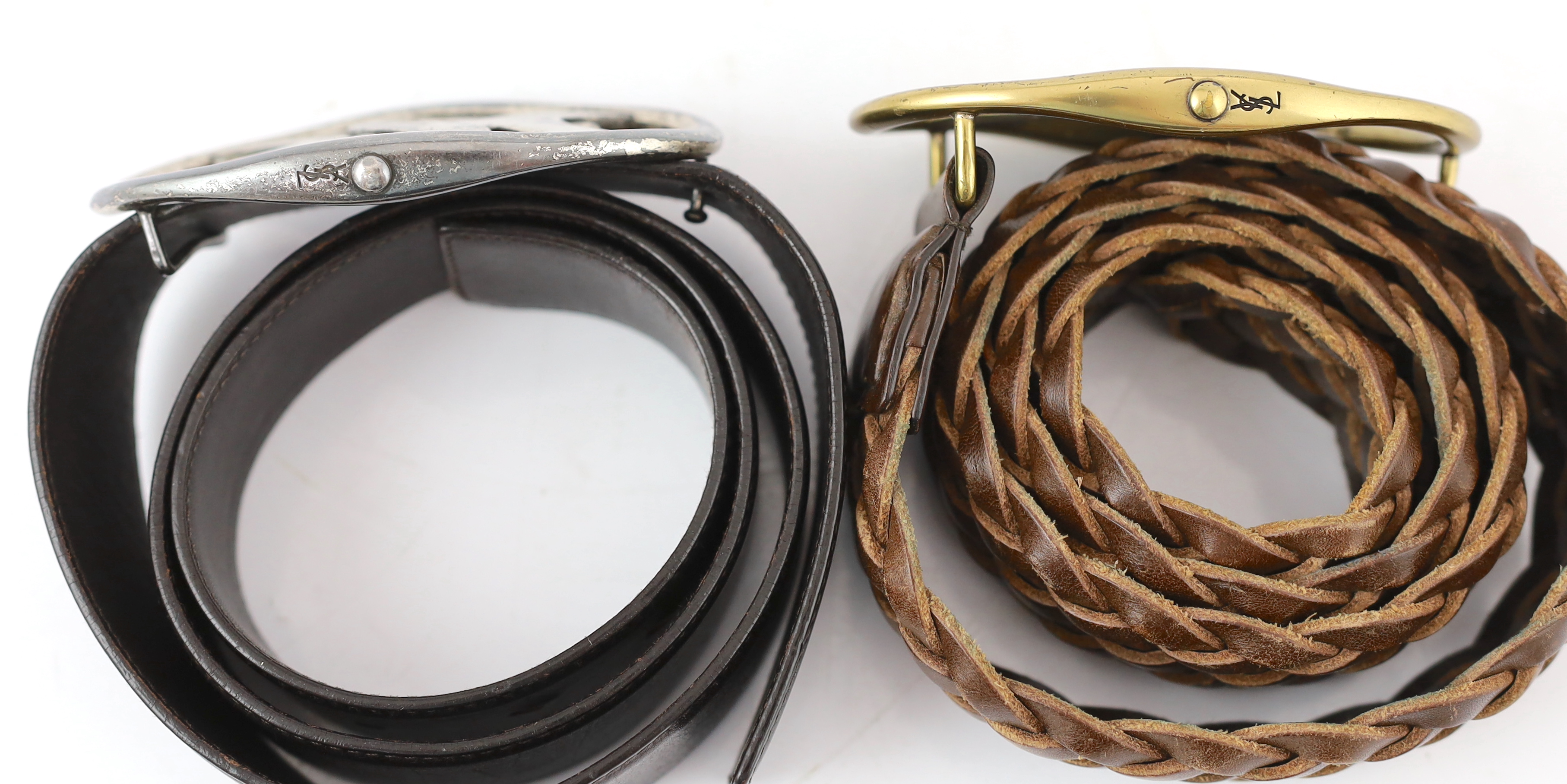 Two Yves Saint Laurent YSL logo belts, one braided tan leather with tarnished gold metalware and the other chrome metal ware with dark brown leather, tan leather size 90-36, dark brown size 85-34